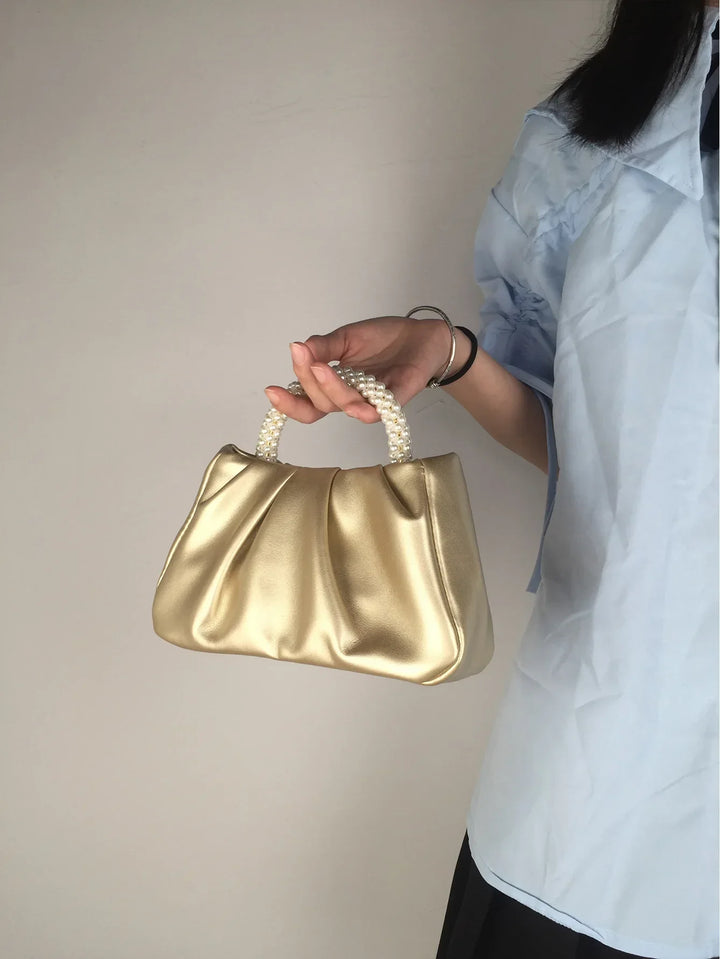 Modèle portant un élégant sac de soirée bandoulière, accessoire chic pour femme.