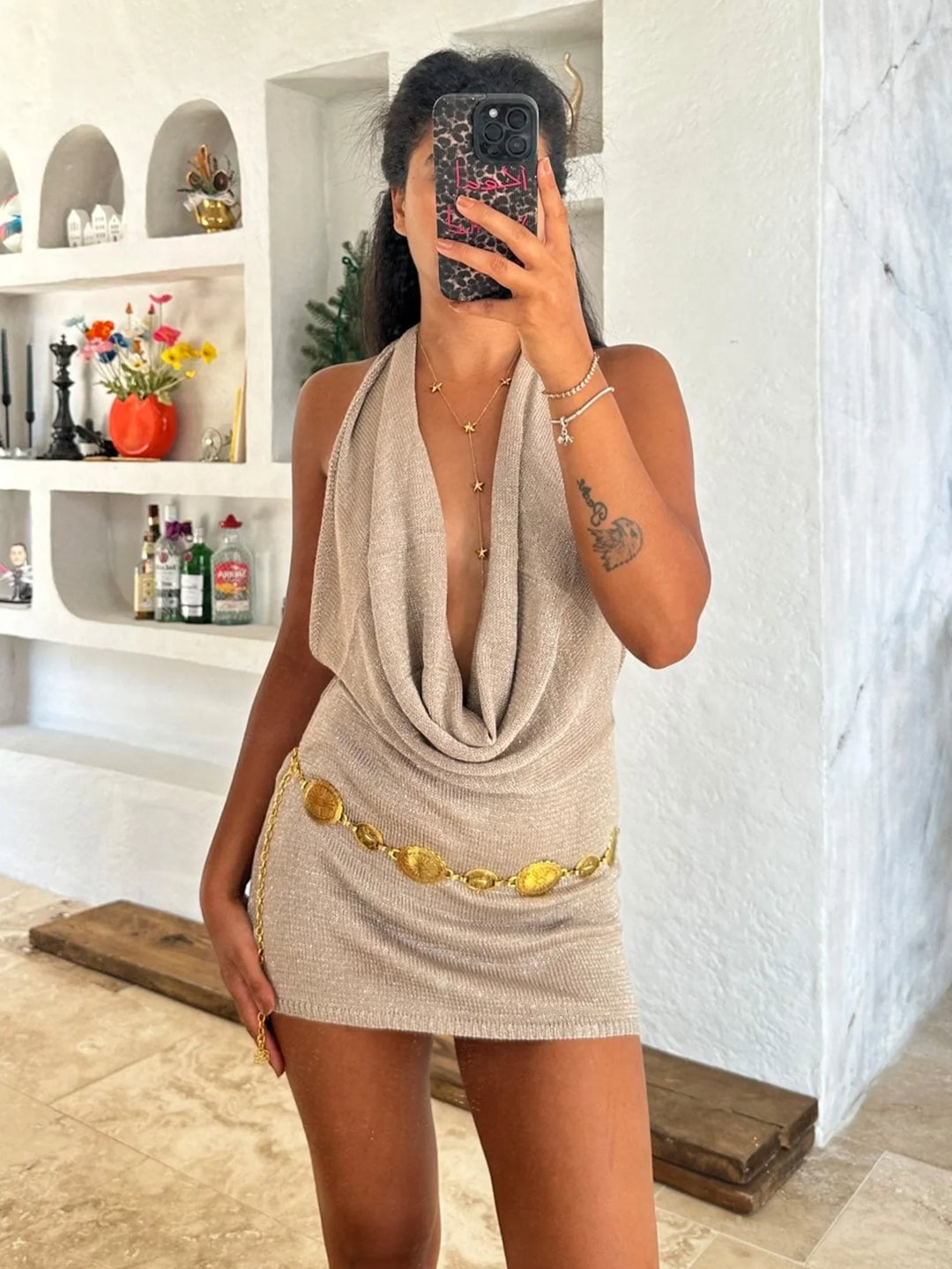 Robe glamour femme, mini pailletée avec un dos nu audacieux et un col V drapé. Parfaite pour les fêtes.