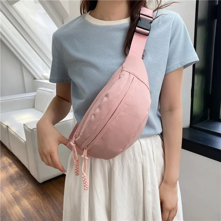 Sac banane femme élégant en nylon noir, accessoire mode pratique pour le quotidien, voyage ou sport.