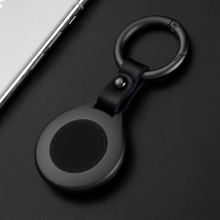 Étui AirTag luxe en cuir noir et métal argenté, protection élégante.