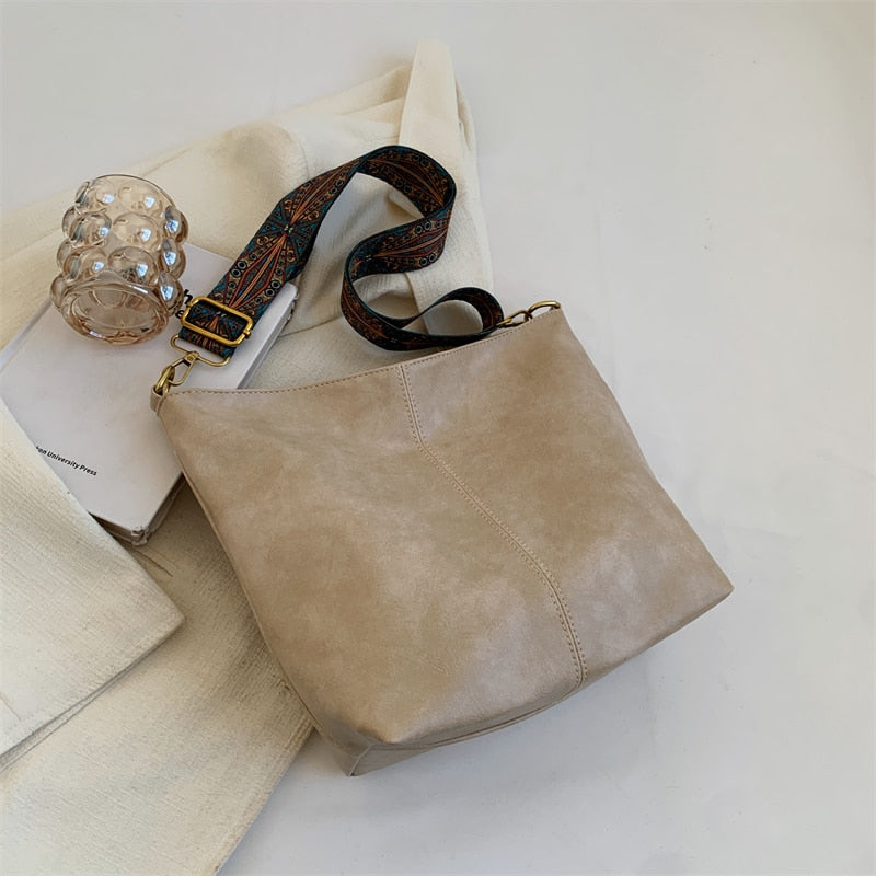 Sac seau femme beige en matière vegan durable, avec bandoulière, accessoire vintage et pratique.