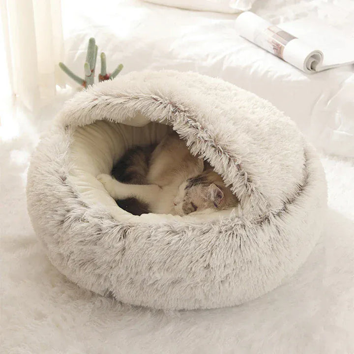 Chaton noir se blottissant dans un lit chauffant en peluche, un couchage douillet parfait pour les nuits froides.