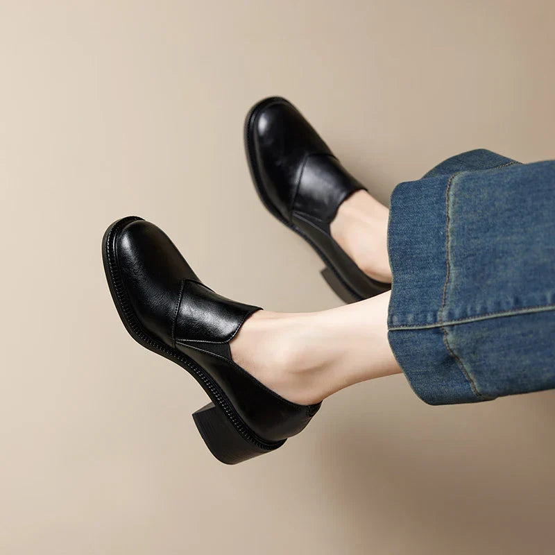 Paire de mocassins femme noirs élégants pour l'été, avec talon large et bout rond pour un confort chic.