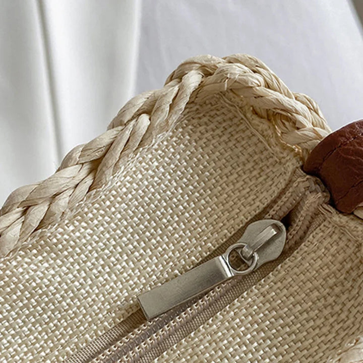 Sac demi-lune en paille tressée et similicuir. Style bohème-chic pour femme, un essentiel estival.
