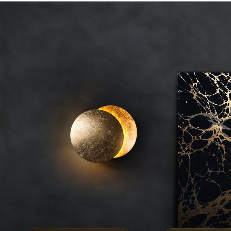 Applique murale LED design Eclipse Solaire dorée pour un salon moderne.