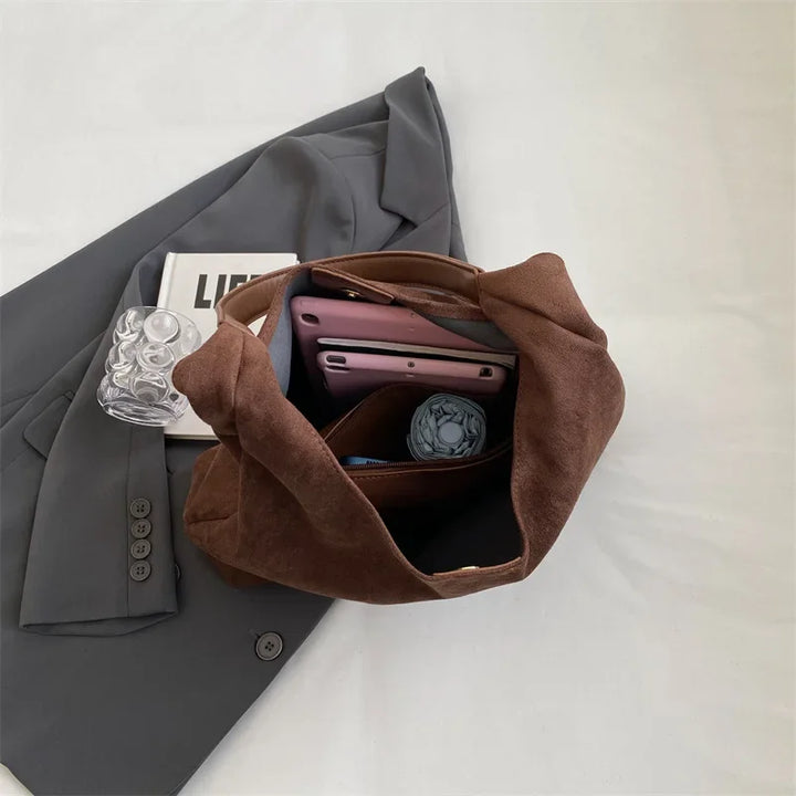 Sac besace femme chic et polyvalent en daim marron, un complément parfait pour le look automnal.