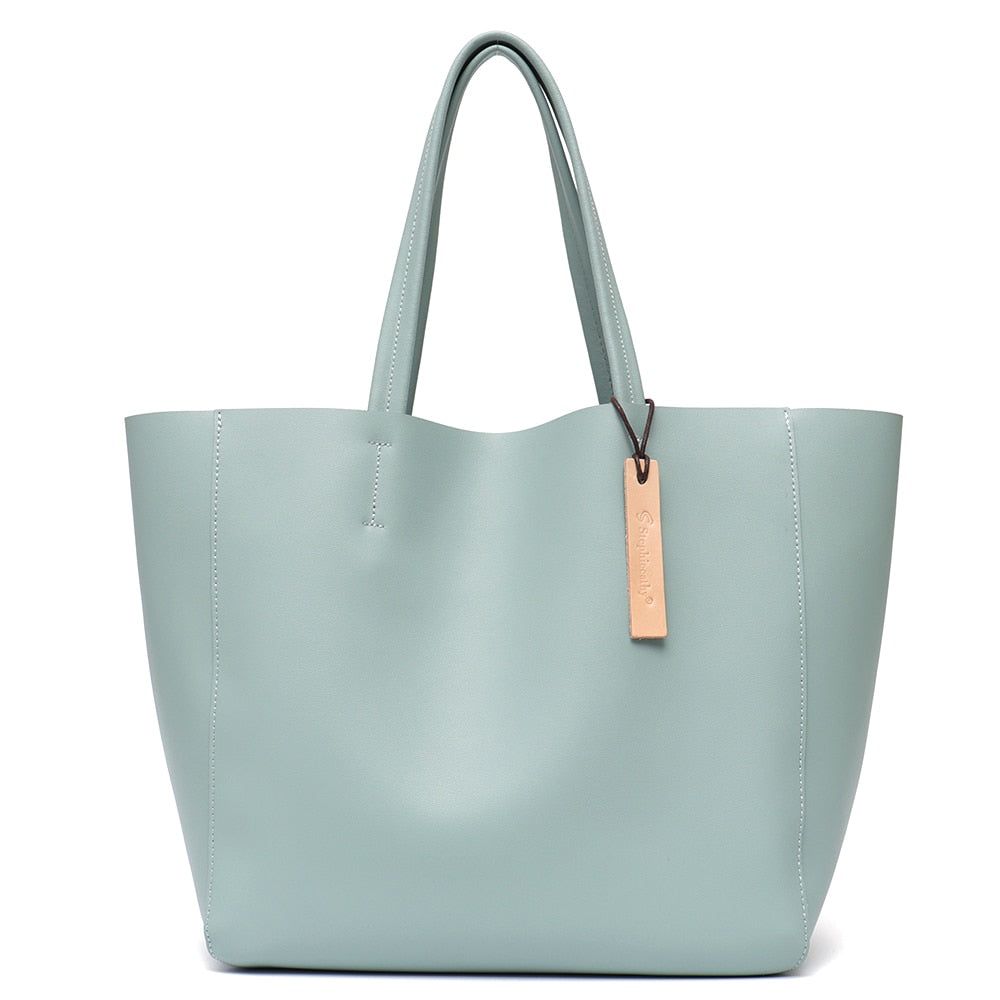 Sac cabas en cuir véritable, porté épaule par une femme, style décontracté chic au quotidien.