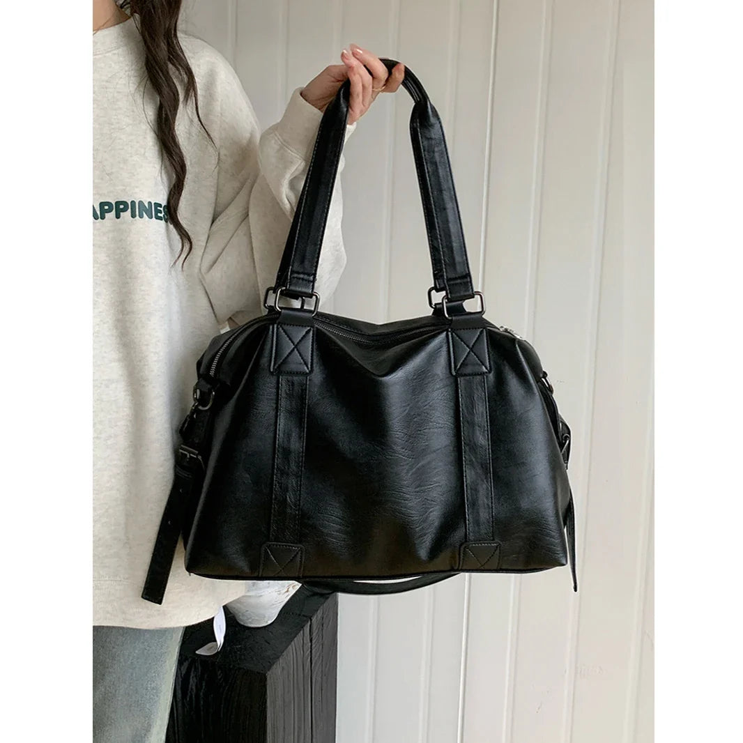 Sac cabas femme élégant en similicuir noir, idéal pour le quotidien, avec bandoulière pratique et organisateur.