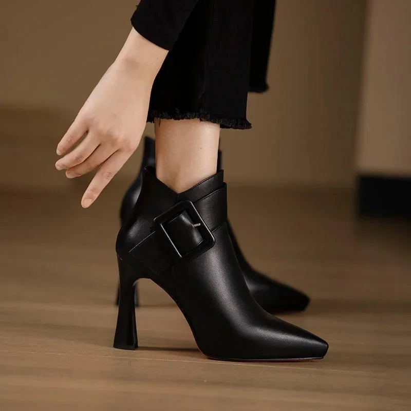 Détail des boucles décoratives sur bottes femme noires élégantes, style tendance et féminin.