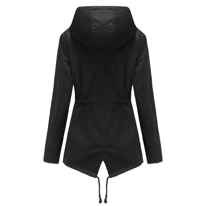 Femme portant un manteau imperméable à capuche, marchant sous la pluie, mode et protection extérieure.