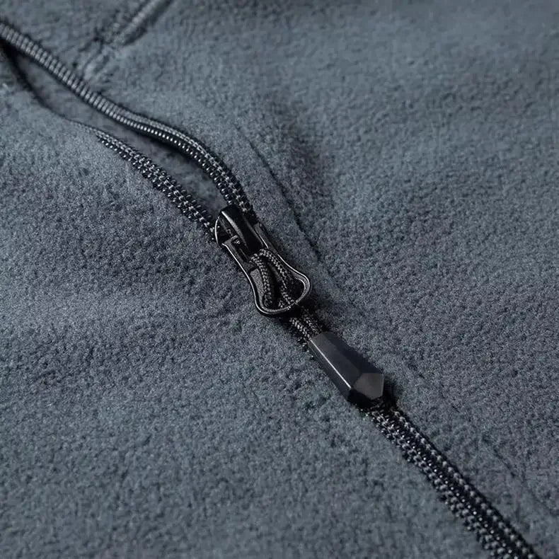 Gros plan sur le tissu polaire doux et le col demi-zip de ce pull homme, gage de chaleur et de confort.