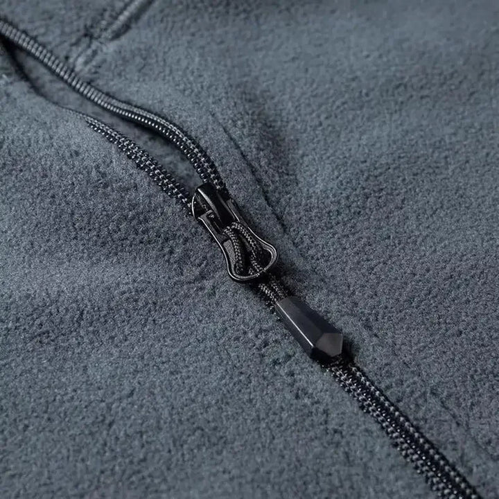 Gros plan sur le tissu polaire doux et le col demi-zip de ce pull homme, gage de chaleur et de confort.