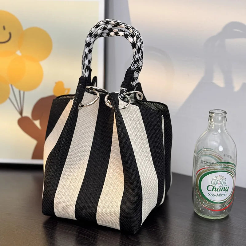 Accessoire mode femme : sac seau tissé à rayures, nouvelle collection printemps-été, chic et polyvalent.