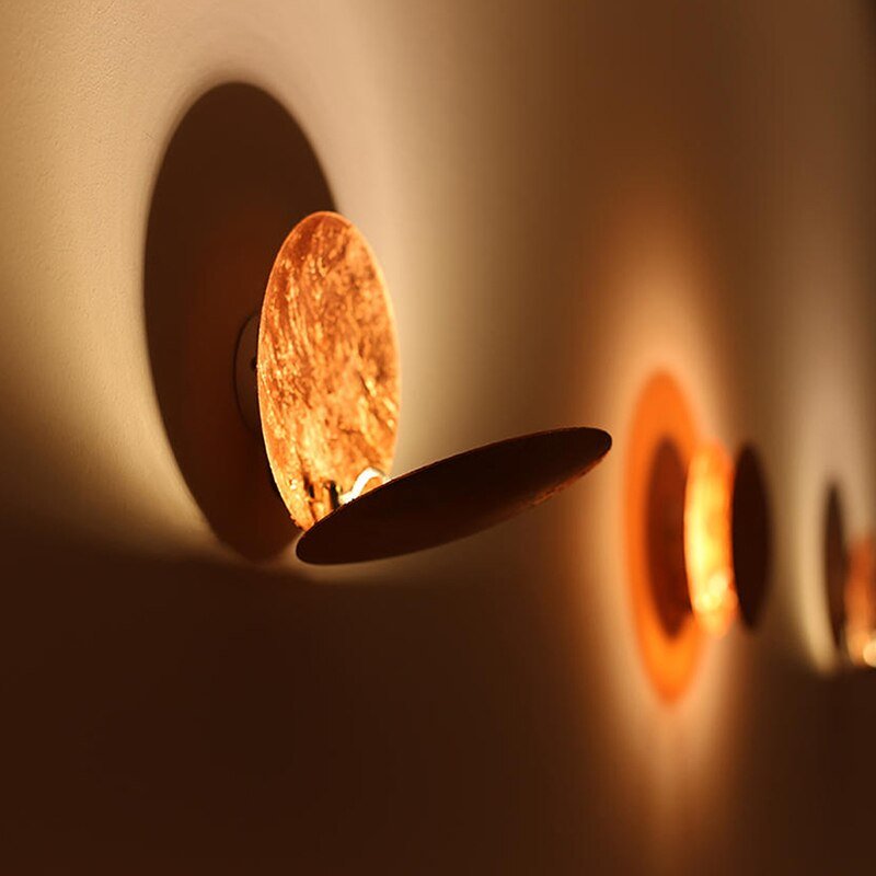 Luminaire mural LED moderne or/cuivre, design eclipse, pour ambiance intérieure chaleureuse et stylée.