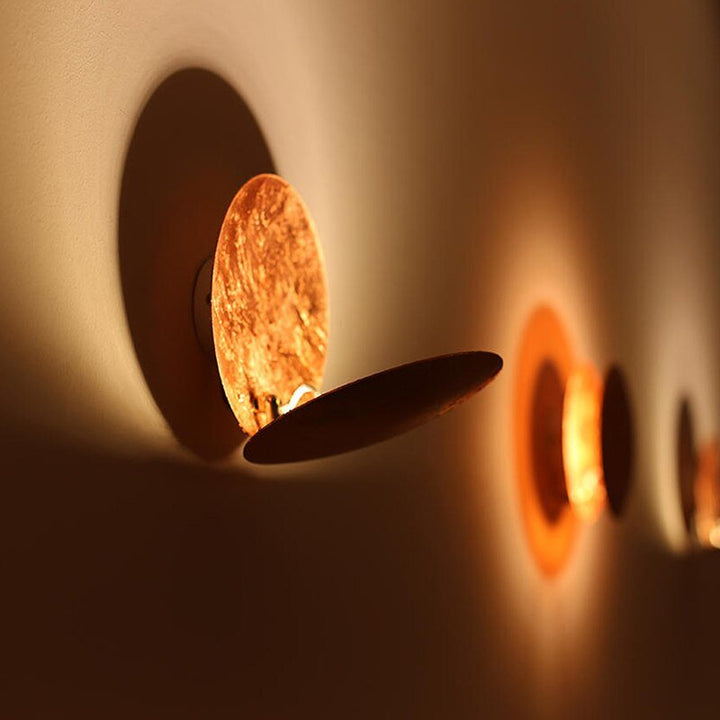 Luminaire mural LED moderne or/cuivre, design eclipse, pour ambiance intérieure chaleureuse et stylée.