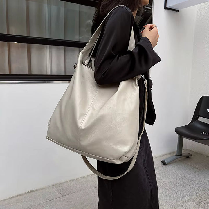 Femme active avec un sac cabas bandoulière vert en cuir vegan, style quotidien.