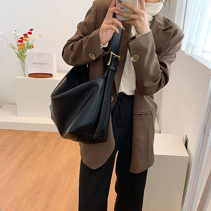 Grand sac cabas noir en cuir vegan pour femme, avec fermeture éclair, spacieux et accessoire mode essentiel.
