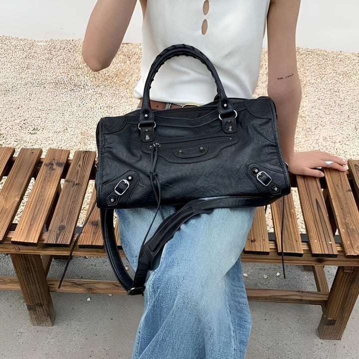 Femme portant un sac à main noir spacieux en cuir PU, look quotidien élégant et pratique.