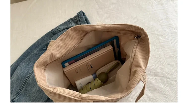 Gros plan sur la texture douce d'un sac cabas en velours côtelé, sac femme hiver original.