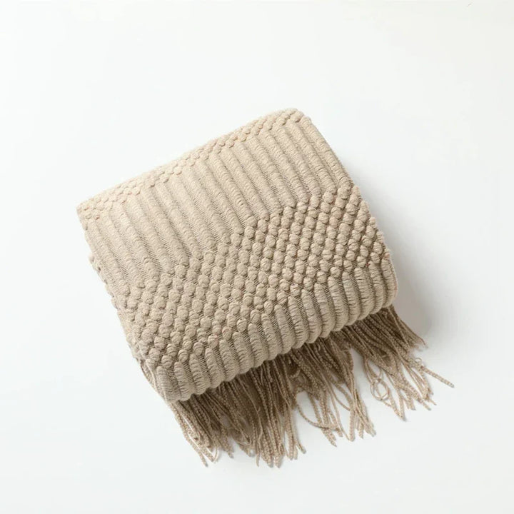 Texture douce et mailles épaisses de cette couverture tricot bohème, invite à la détente et au confort.