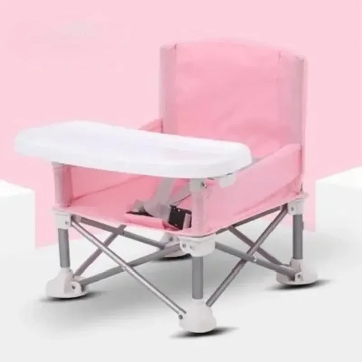 Bébé heureux dans sa chaise de repas pliante avec plateau intégré. Confort et sécurité pour chaque repas.