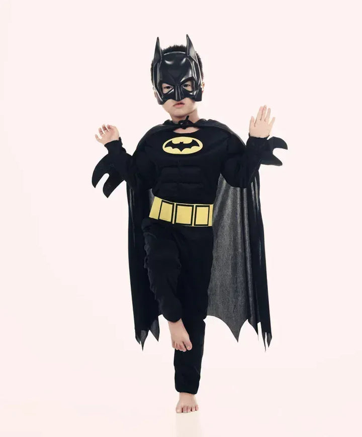 Petit fan de super-héros en déguisement Batman complet avec cape et masque, posant. Idéal pour les fêtes costumées.