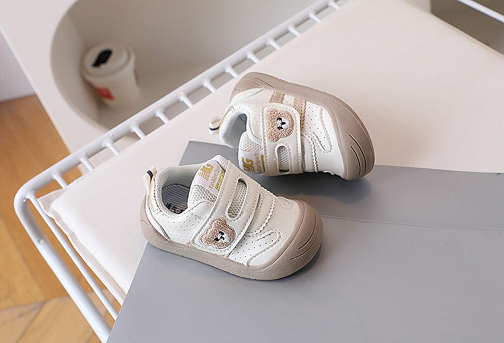 Chaussures bébé ergonomiques rouges en textile, offrant un soutien doux et une flexibilité accrue pour marcher.