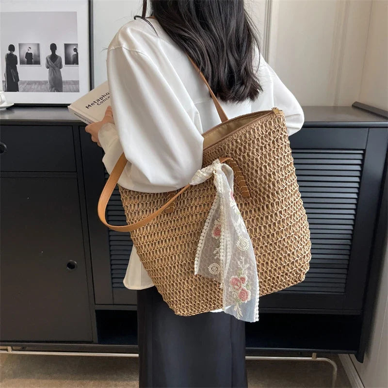 Femme portant un sac cabas en paille bohème chic beige, parfait comme sac de plage ou pour un look d'été naturel.
