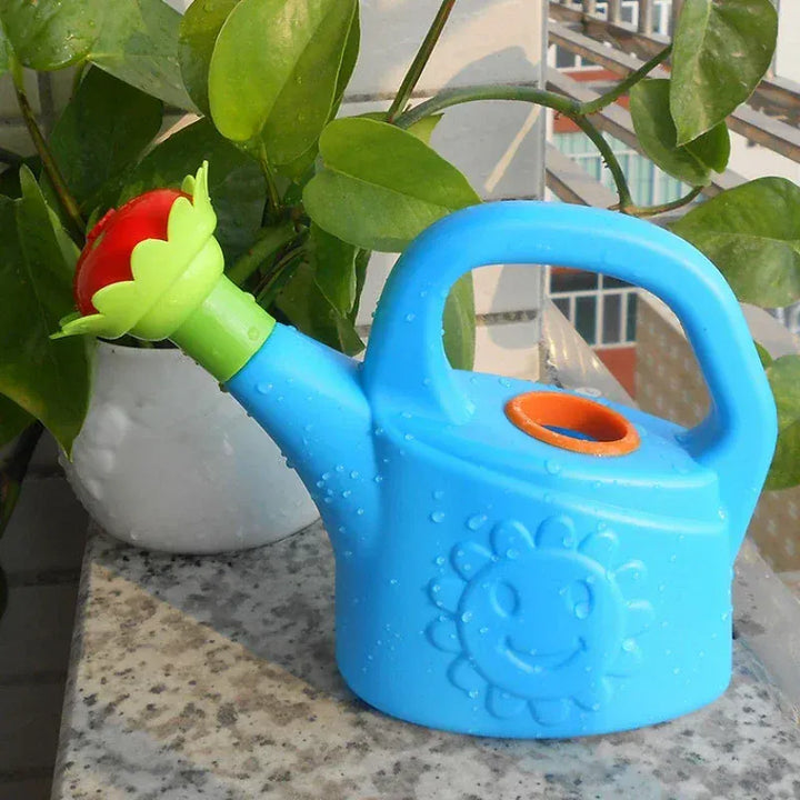 Enfant jouant avec arrosoir et pulvérisateur d'eau pour jardin ou plage, activité extérieur été.