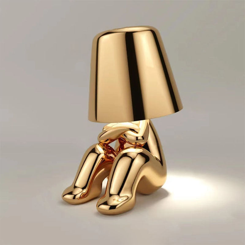 Lampe de table LED élégante, ornement homme stylisé or, design moderne, lumière d'ambiance pour intérieur.