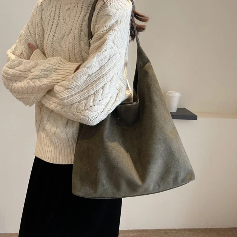 Sac besace en daim véritable pour femme, accessoire chic et raffiné, idéal porté épaule.