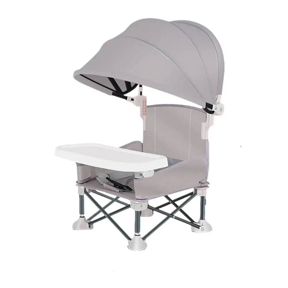 Bébé confortablement installé dans sa chaise haute portable avec pare-soleil pour repas extérieur ou pique-nique.