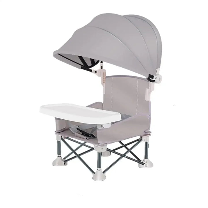 Bébé confortablement installé dans sa chaise haute portable avec pare-soleil pour repas extérieur ou pique-nique.