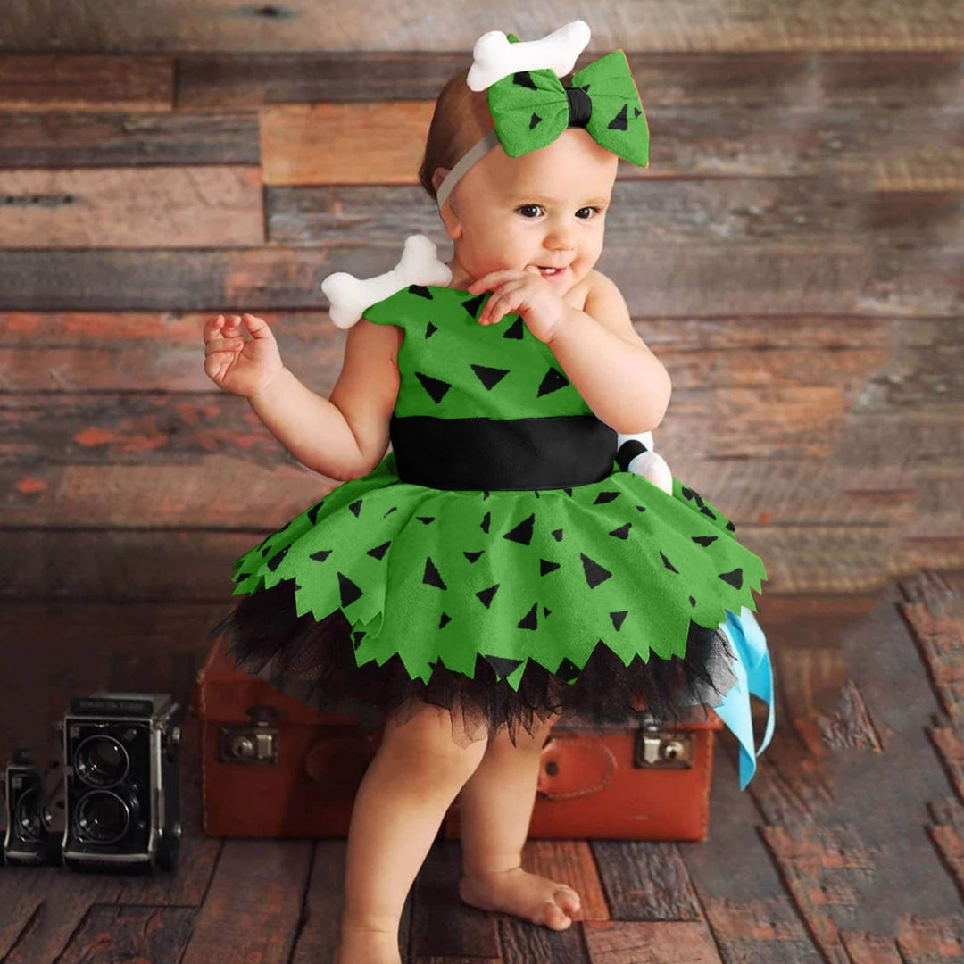 Costume Pierrafeu bébé fille. Robe verte, motifs orange, bandeau rose. Pour fêtes à thème préhistoire ou carnaval.