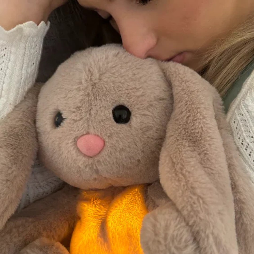 Enfant câlinant un lapin en peluche respirant, favorisant le sommeil et la relaxation. Confortable et apaisant.