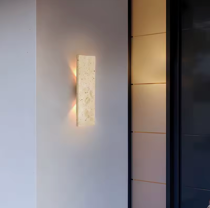 Applique murale extérieure LED illuminant une terrasse la nuit. Crée une ambiance chaleureuse et sécurisée.