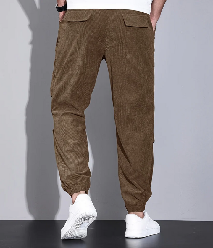 Homme portant un pantalon confortable gris, coupe décontractée pour une tenue quotidienne et stylée.