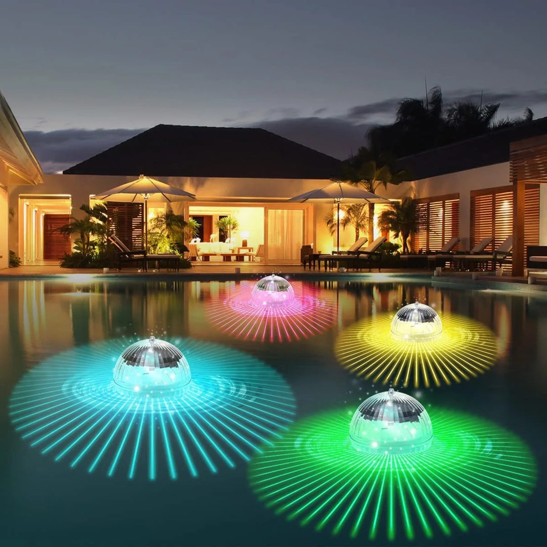 Boule LED solaire RGB flottante illuminant une piscine la nuit, créant une ambiance colorée et festive.