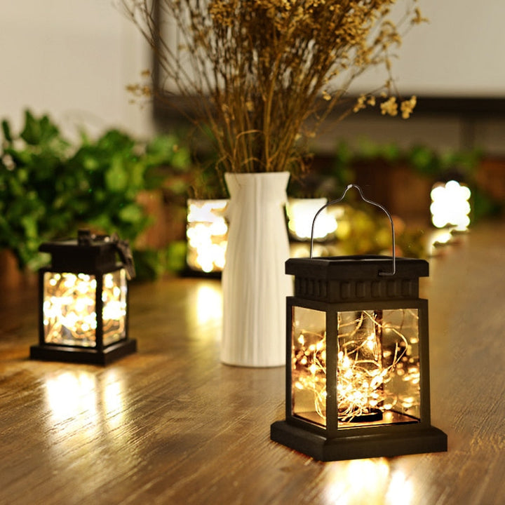 Décoration extérieure: lanterne solaire LED noire avec panneaux en verre. Crée une ambiance chaleureuse sans fil pour jardin.