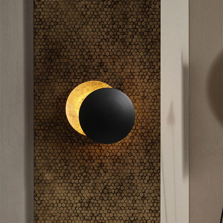 Applique murale LED design eclipse solaire, décoration intérieure contemporaine, finition or brillant.