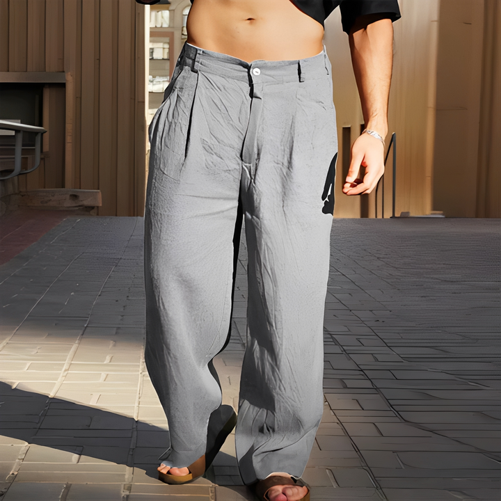 Homme portant un pantalon ample et moderne, idéal pour l'été. Un style décontracté chic pour la plage.