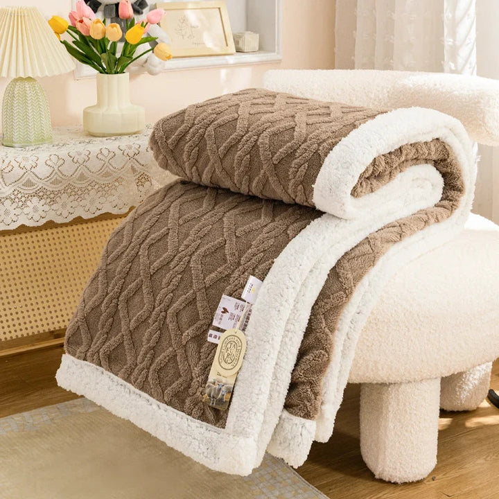 Couverture chaude et douillette en sherpa, parfaite pour se blottir sur le canapé en hiver.