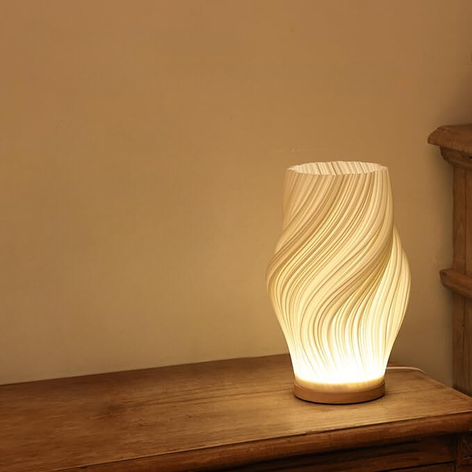 Lampe de bureau LED minimaliste, design ondulé, éclairage fonctionnel et stylé.