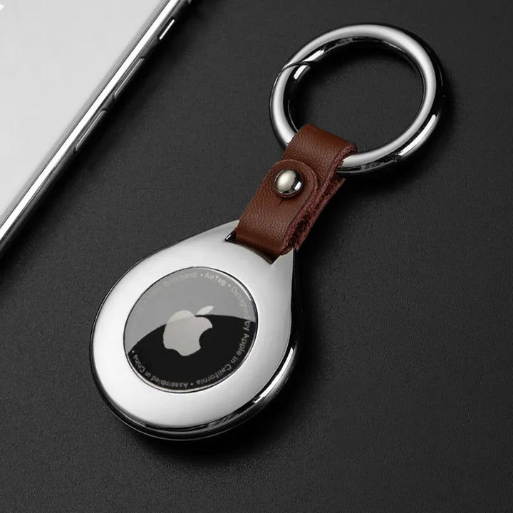 Étui AirTag en cuir noir, métal argenté, offrant une protection élégante et discrète.