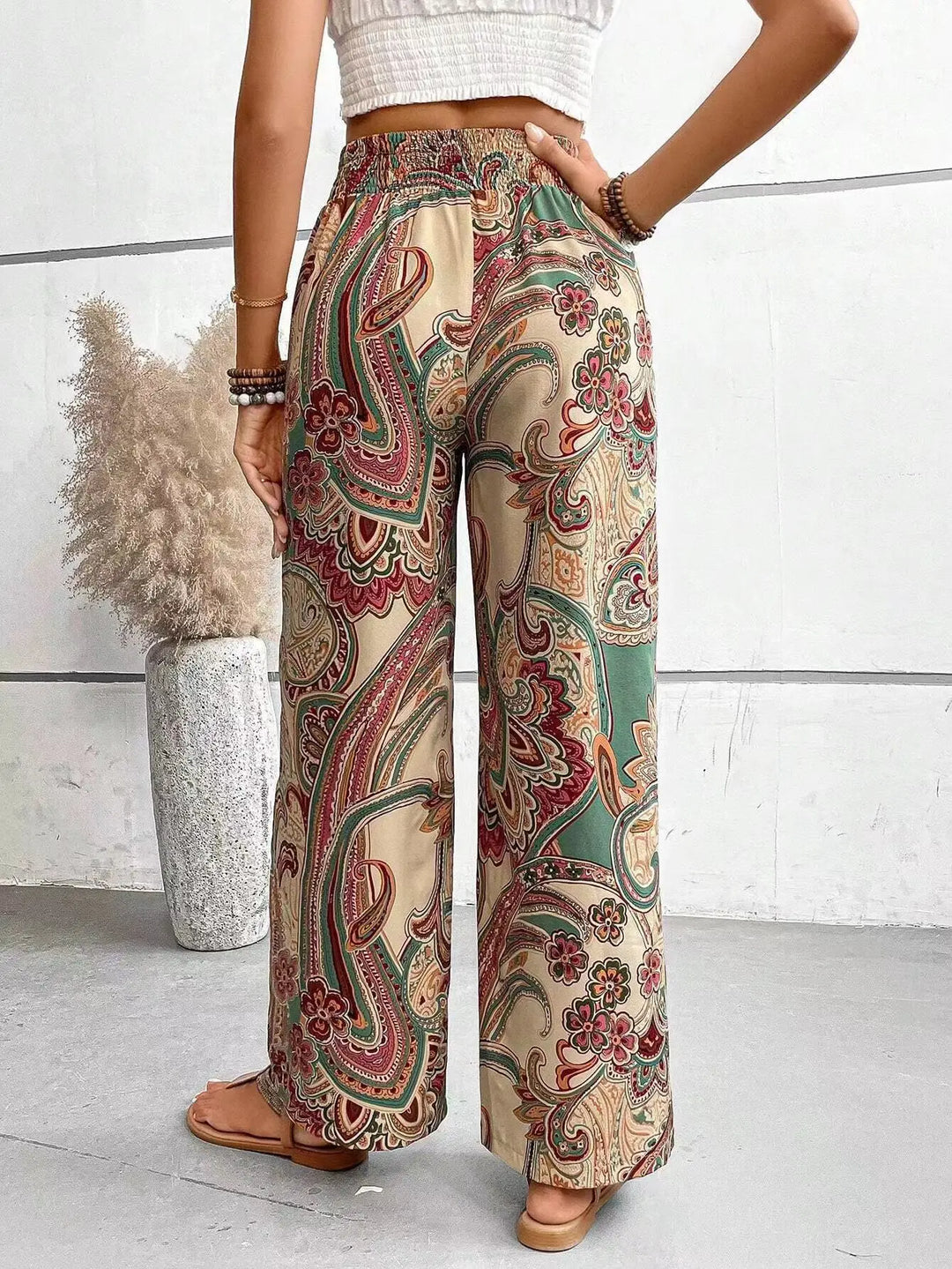 Femme portant un pantalon large imprimé vintage taille haute, élégant pour le bureau ou une tenue casual chic.