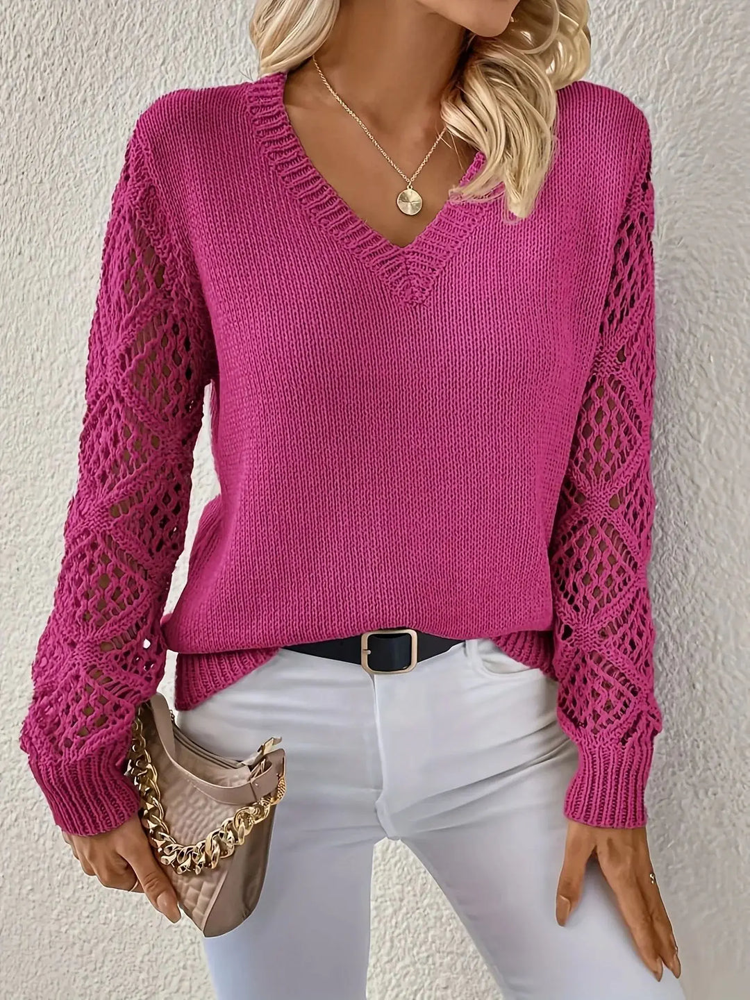 Pull femme chic à col V. Manches ajourées délicates et matière confortable, idéal pour la mi-saison élégante.