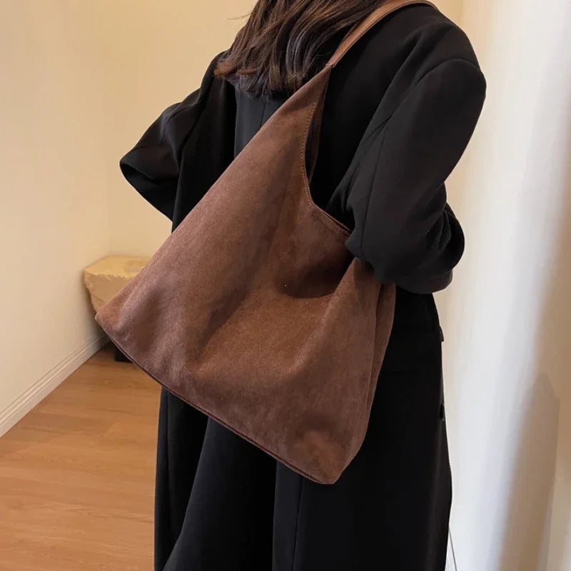 Sac à main besace noir en daim, style élégant et intemporel, parfait pour toute tenue chic.