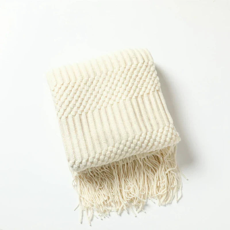 Couverture de canapé tricotée, couleur neutre, avec motif bohème, pour une déco salon naturelle.