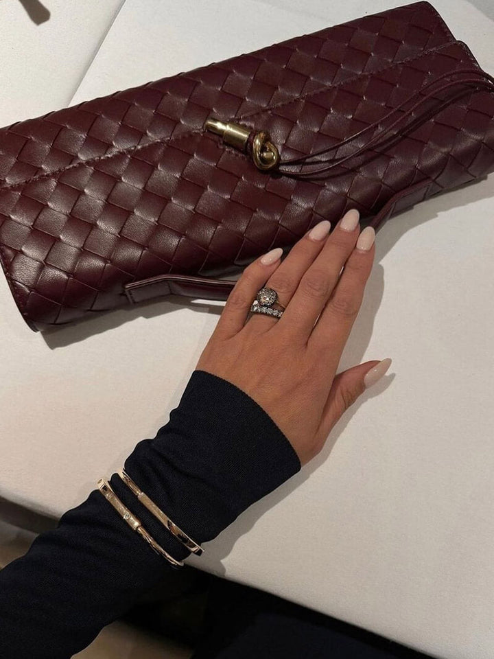 Sac de luxe avec texture tissée, fermoir doré, accessoire essentiel pour une femme chic.