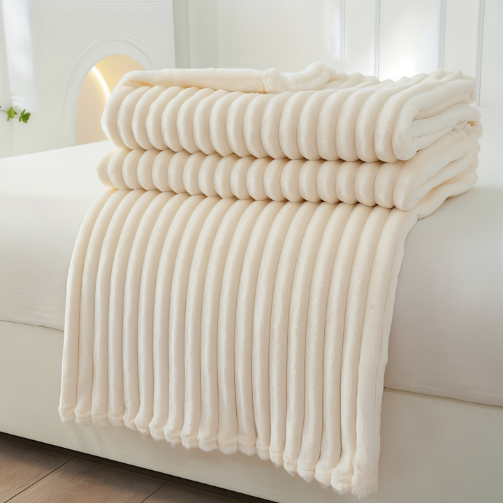 Jeté de lit polaire rayé, doux, apportant chaleur et confort à la chambre.
